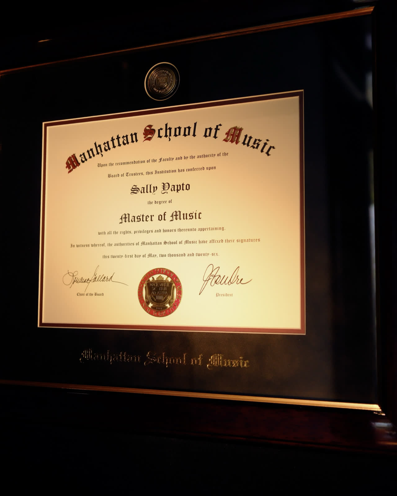 Sally Yapto’s Master of Music diploma from the Manhattan School of Music, framed on the studio wall.