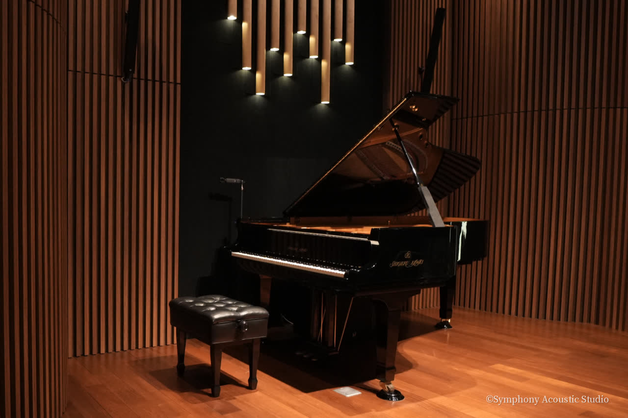 The Shigeru Kawai concert grand close up on the stage of Symphony Hall, lid open, a microphone on its stand beside the keyboard.