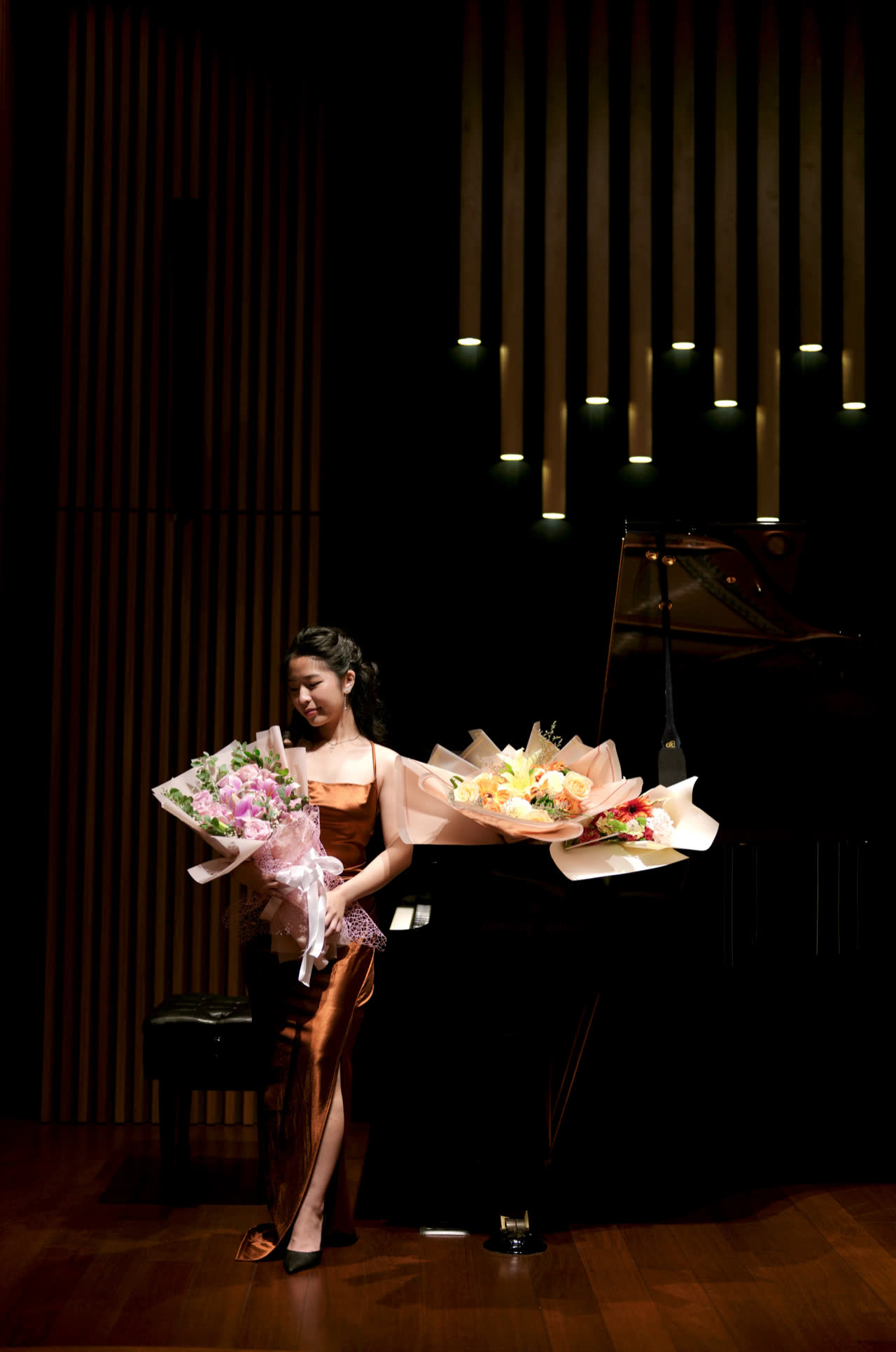 Sally Yapto on stage after a recital, holding bouquets.