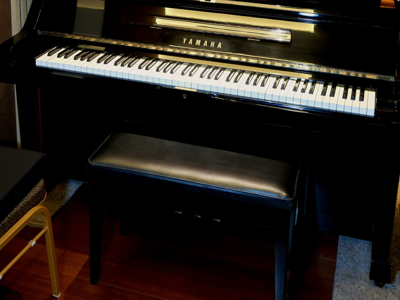 The keyboard and bench of the studio's Yamaha upright piano.